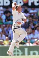 SHANE WARNE: A colour picture of Shane Warne running into bowl, autographed by Shane Warne