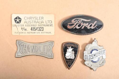 BADGES: A collection of badges and plaques including three enamelled badges Ford, Oldsmobile and Plymouth badges. A Chandler badge and Chrysler Australia paper tag.