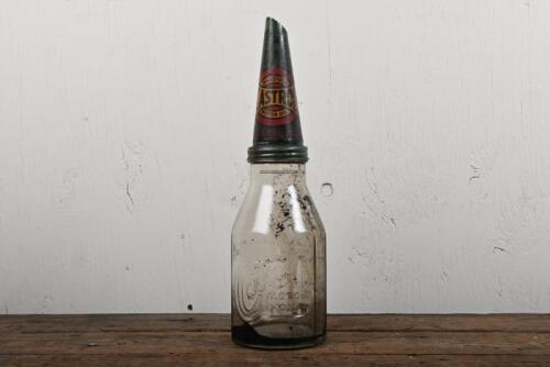 CASTROL WAKEFIELD: A circa 1950s Castrol Wakefield embossed one imperial quart glass oil bottle with circa 1910 Castrol Wakefield tin oil pourer, remnants of liquid in bottle