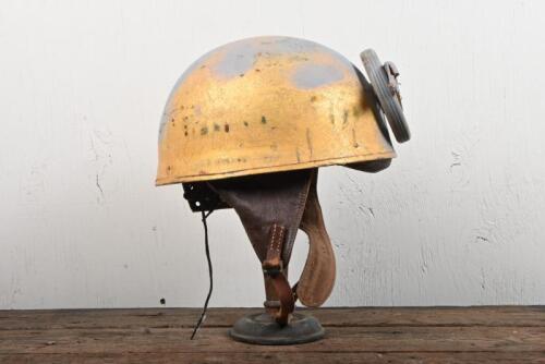 HELMET: A WWII BOMB (British Motor Bodies) dispatch riders helmet dated 1944, with leather interior and later applied winged wheel and medallion, size 6 3/4