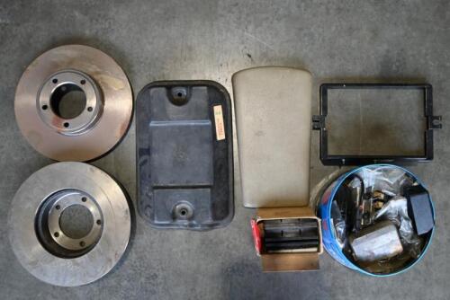 JAGUAR: XJS. One NOS pair of front disc rotors and brake pads. One tin of used assorted Jaguar XJS parts. One battery cover. One battery lead cover box. One battery frame. One central arm rest.