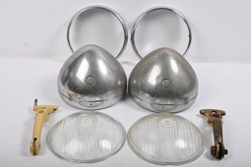 MG: "T SERIES". One pair of MG TC headlamp shells and rims plus two glass lenses. One pair of headlamp mounting brackets. One pair of headlamp rims.