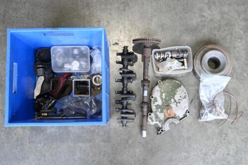 MG: "T-SERIES" PARTS. One blue box of assorted MG parts. Camshaft and sprocket. Timing case cover. Thermostat housing. Tappet assembly. Main bearing cap. 32 door hinge pins. Assorted Cam buckets. Two steering box worms and parts.