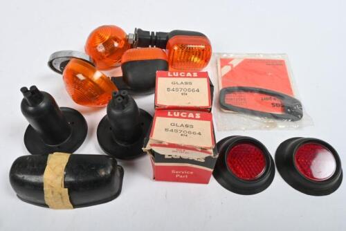LAMPS: One pair of blinker assemblies with separate reflectors. Two Lucas amber lenses. One pair red reflector lamps with rubber housing. Two NOS red Lucas glass lenses. One number plate lamp. Two rubber park lamp housings.