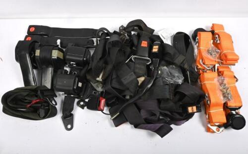 SAFETY BELTS: one box of black safety belts. Inertia wheel and normal type with assorted fasteners. One pair of NOS safety belt harnesses with four way rotary release catches in gold.