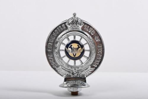 RACV: A Royal Automobile Club of Victoria front bumper members badge,&nbsp;Australian Red Ensign centered on one side, RACV logo on reverse side. '4580' engraved to base along with 'Property of the RACV' engraved to Australian Red Ensign side base