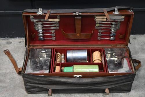 PICNIC BASKET: An unusual early motoring leather bound picnic basket with outer leatherette case