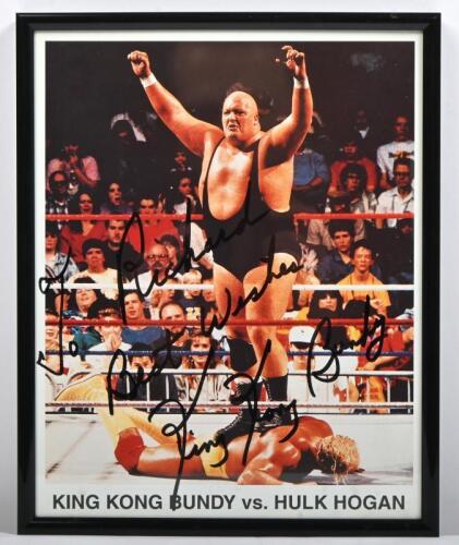 KING KONG BUNDY: A framed and glazed colour picture of King Kong Bundy vs Hulk Hogan, personally inscribed and signed by King Kong Bundy