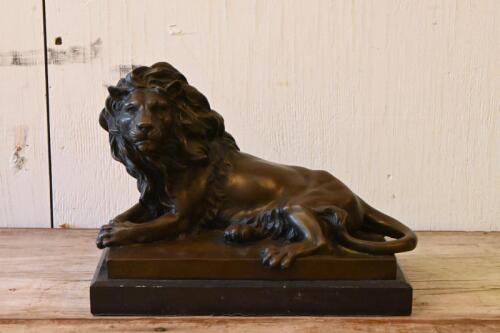 AFTER BARYE: A cast bronze figure of a recumbent lion on black marble base after the original model by Antoine-Louis Barye (French, 1795-1875), 20.5cm high