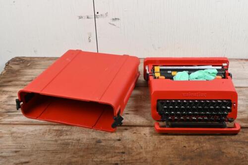 OLIVETTI: A circa 1970s Valentine red ABS plastic and powder coated metal portable typewriter in carrying case designed by Ettore Sottsass and Perry King for Olivetti, the case 11.5cm high, 34cm wide, 35cm deep