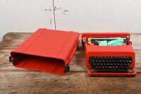 OLIVETTI: A circa 1970s Valentine red ABS plastic and powder coated metal portable typewriter in carrying case designed by Ettore Sottsass and Perry King for Olivetti, the case 11.5cm high, 34cm wide, 35cm deep