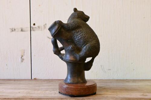BRONZE: A cast bronze figure of a small brush tail mammal on bamboo, on a marble base, 25cm high