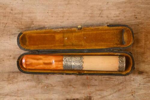 CIGAR HOLDER: A early cigar holder in case made from English silver and believed to be&nbsp;amber with engraved detailing