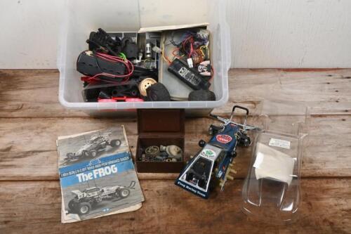 TAMIYA: A 1/10 scale Tamiya&nbsp;'The Frog' off road remote control car along with a&nbsp;tub of spare parts such as wheels, tires, batteries, motor and others.&nbsp;