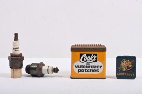 MOTORING: Four vintage motoring items. Australux tin housing four fuses. Spark Plugs