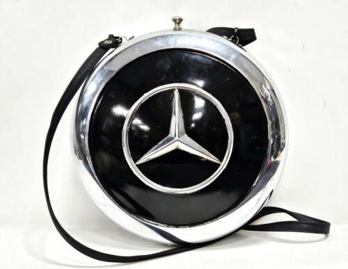 A decorative lined ladies handbag constructed from two Mercedes-Benz hubcaps, 25cm diameter, by automotive artist Terry Lawrie
