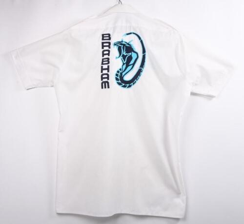 BRABHAM: A 1980's BRABHAM &ldquo;Hissing Sid&rdquo; Formula 1 team shirt featuring a chimera with a lion head, a cobra body, and a scorpion tail, shirt in white with embroidered details, 'PIRELLI' sponsorship to front; size 41 (COA attached)