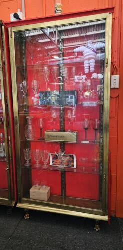 DISPLAY CASE: An antique brass, single door, shallow display case. Measures 197cm high, 96cm wide, 24cm deep