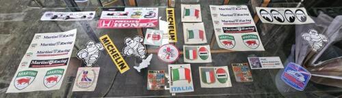 STICKERS: An assortment of motor racing stickers and plaques. 'GIACOMO AGOSTINI MOTORCYCLE-BOOTS' sticker, 'Martini Racing', 'MICHELIN' and 'Moon Equipped' stickers