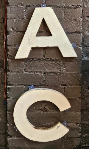 AC: Two tin letters in the form of an 'A' and 'C'