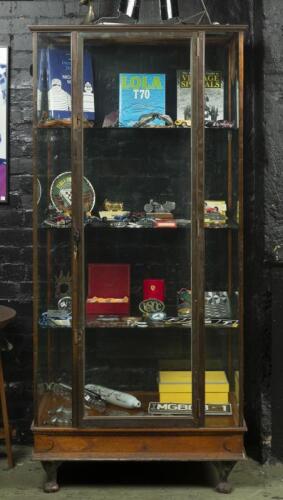 CABINET: An antique timber and brass upright display case. Applied 'Kodak' prints - 'LEAVE FILMS HERE' original advertising sticker. Measures 198 cm high, 92cm wide, 61.5cm deep