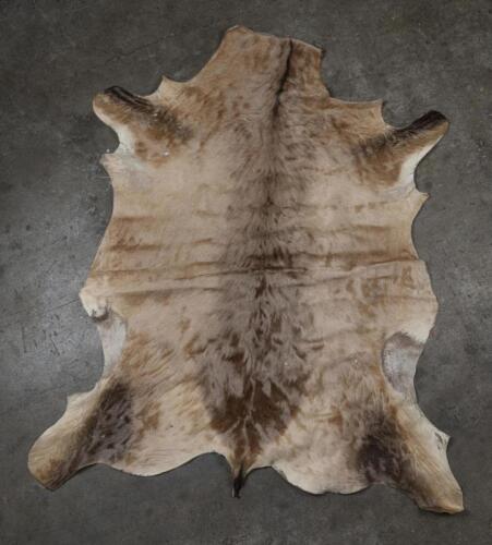 RUG: A large animal hide rug, likely Wildebeest, approx&nbsp;154cm high, 115cm wide at&nbsp;furthest away points