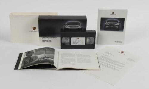 CAYENNE: Two 2002 Porsche Cayenne model brochures. Cardboard case housing a VHS video tape & hardcover Cayenne brochure. Additional Cayenne brochure
