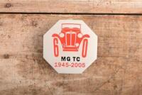 MG TC: A 60th anniversary MG TC commerative badge, new with mounting screws.&nbsp;