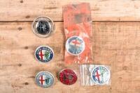 ALFA ROMEO: A group of six Alfa romeo plastic badges including one NOS in original packet part no 2400.51012