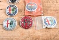 ALFA ROMEO: A group of six Alfa romeo plastic badges including one NOS in original packet part no 2400.51012 - 2