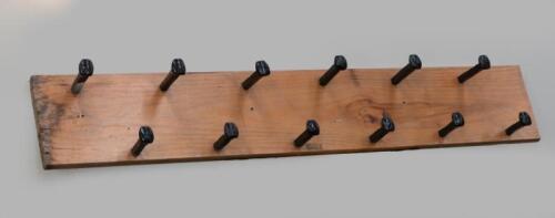 RAILWAYANA: A interesting coat rack made using railway spikes, mounted to timber measuring 147cm long, 24cm wide.