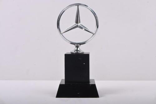 MERCEDES: A Mercedes bonnet emblem mounted to wood presentation base, 17cm high overall.