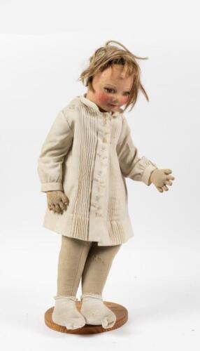 DOLL: A antique paper mache faced doll with stand, measures 76cm tall