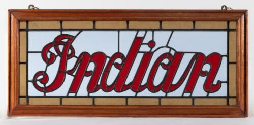 INDIAN: A Indian scripted logo stained glass window within timber frame, 35cm high, 78cm wide overall