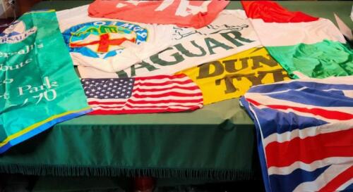 FLAGS: A collection of motoring and national flags including; JAGUAR, DUNLOP TYRES, ALFA ROMEO, TATTERSALLS HISTORIC ETC