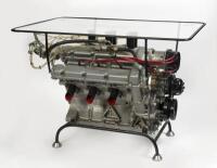 A superbly designed steel framed, glass topped coffee table featuring a gutted Ferrari Dino Motor with faux injection, etched glass top reading 'Ludovico Scarfiotti European Mountain Champion 1965', with prancing horse motifs to corners.&nbsp;
