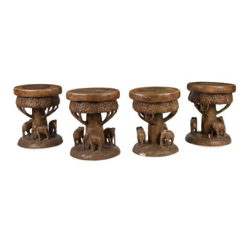A set of four solid teak carved elephant stools, 47cm high, 40cm wide