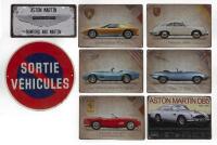 SIGNS: A selection of eight reproduction&nbsp;tin signs including Porsche, Ferrari, Aston Martin etc. As well as an aluminum&nbsp;'SORTIE VEHICULES' sign.