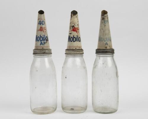 MOBIL: A set of three One Quart Mobil glass oil bottles with tin Mobil pourers