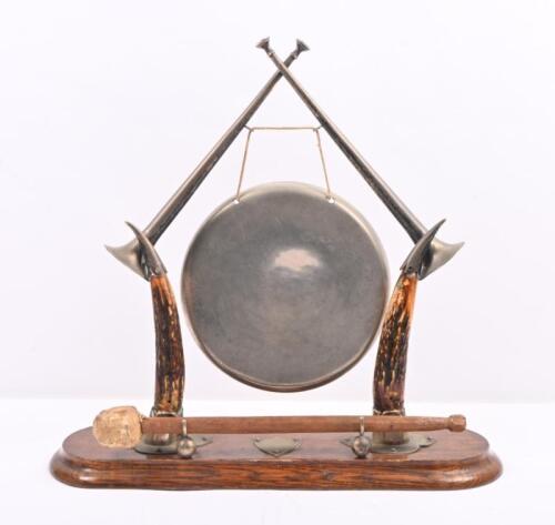 DINNER GONG: An antique dinner gong with horns mounted on wooden base, gong hanging from trumpets, complete with period striker. 38cm high