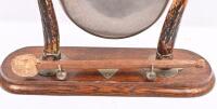 DINNER GONG: An antique dinner gong with horns mounted on wooden base, gong hanging from trumpets, complete with period striker. 38cm high - 2