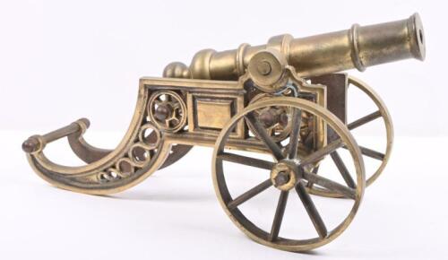 CANNON: A decorative brass cannon on wheels, approx 38cm long.