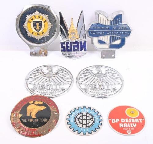 BADGES: A collection of eight interesting badges including Triumph Sports Owners Association, Automovel Club Do Brasil, and others. Largest approx 10 cm wide.