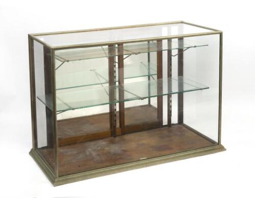 DISPLAY CASE: An antique brass and glass display case, makers plaque on base reads 'Boston Co. Fitzroy', 118cm wide, 54cm deep, 84cm high.