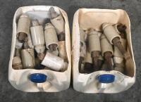 INSULATORS: A large selection of ceramic telephone wire insulators, mostly affixed to wooden posts.