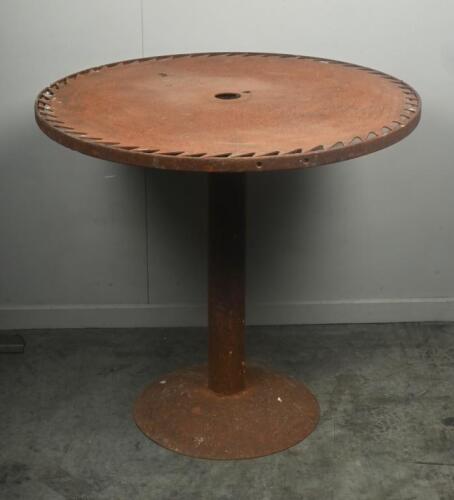 TABLE: A medium sized rustic standing table with saw blade top, mounted to circular base. 78cm tall