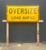 OVERSIZE LOAD: A large 'Oversize Load Ahead' metal sign mounted to timber stand along with flag set and banner