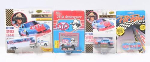 RICHARD PETTY #43: Set of 4 Richard Petty #43 NASCAR collectibles, 3 1:64 scale stock cars, and 1 1:87 scale official team transporter truck and trailer, all plastic display wrapped.