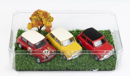353 · MINIS: Set of 3 1:43 scale Minis, 1 Red and White Corgi Toys Morris Mini-Minor rally/race car #39, 1 Vanguard LLedo Mustard and White Mini Cooper, and 1 Vanguard LLedo Red and Black Mini Cooper, housed in a clear display box.