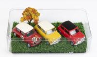 MINIS: Set of 3 1:43 scale Minis, 1 Red and White Corgi Toys Morris Mini-Minor rally/race car #39, 1 Vanguard LLedo Mustard and White Mini Cooper, and 1 Vanguard LLedo Red and Black Mini Cooper, housed in a clear display box.